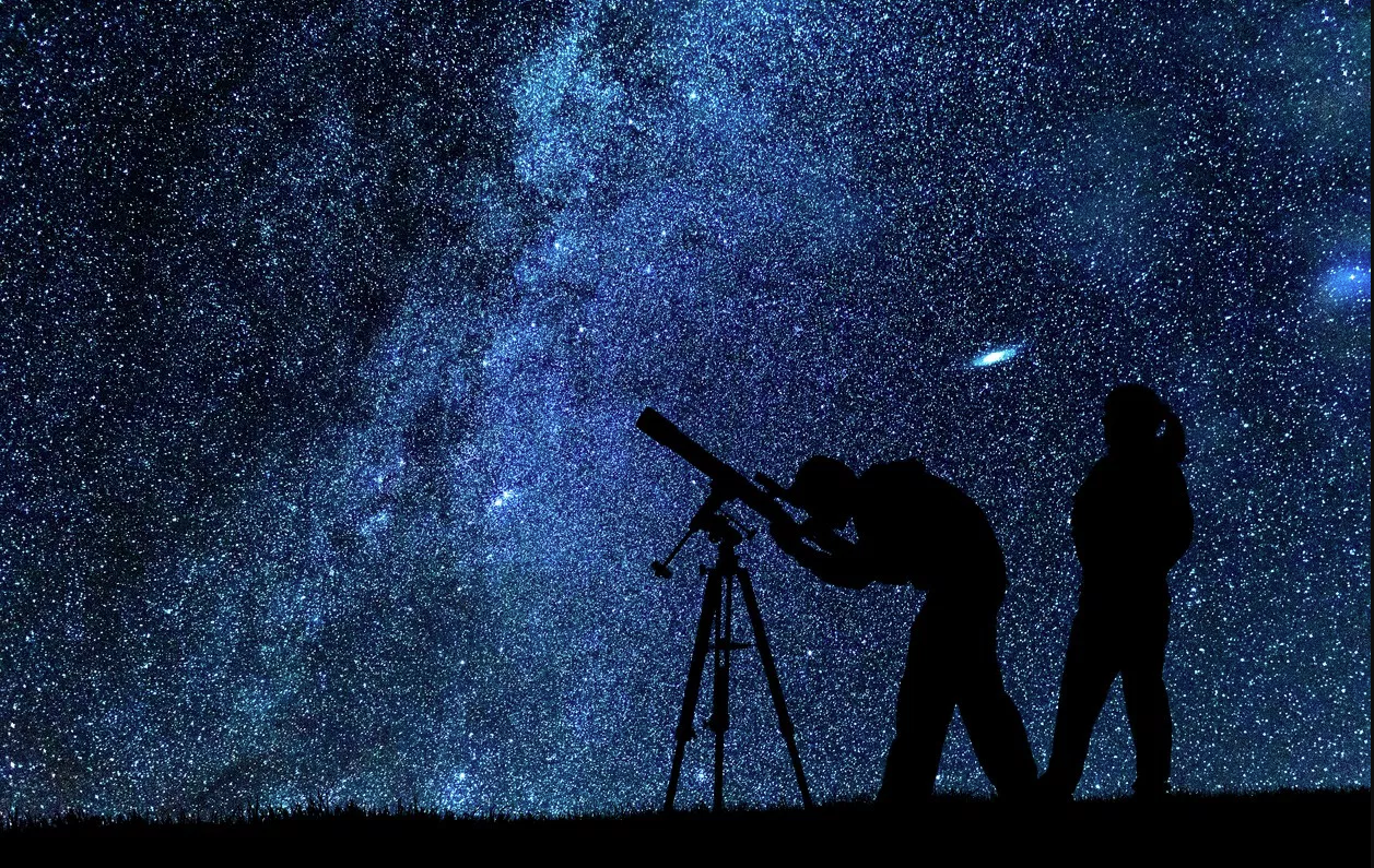 Couple looking at stars through telescope